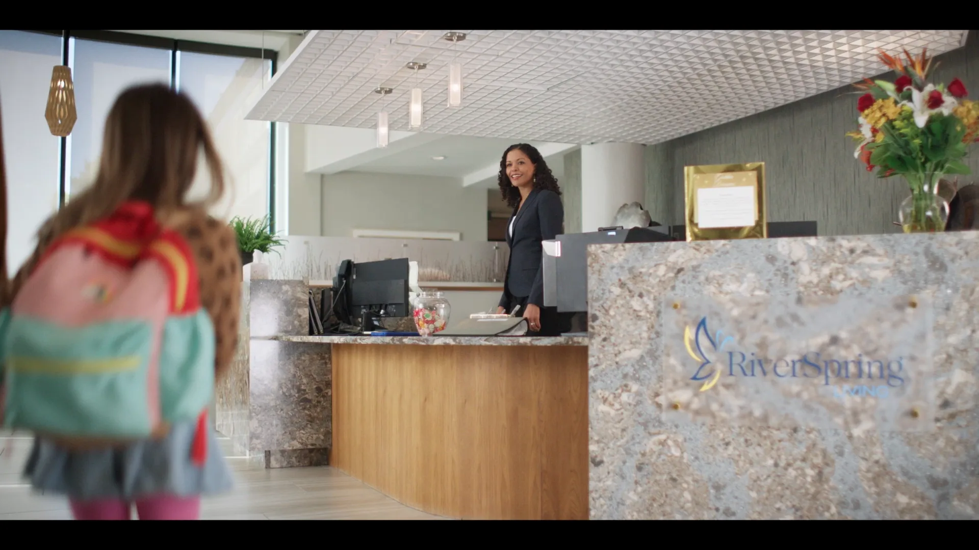 A girl arrives at the RiverSpring Living reception desk